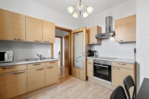 Una cocina moderna con armarios de madera, horno empotrado y microondas.