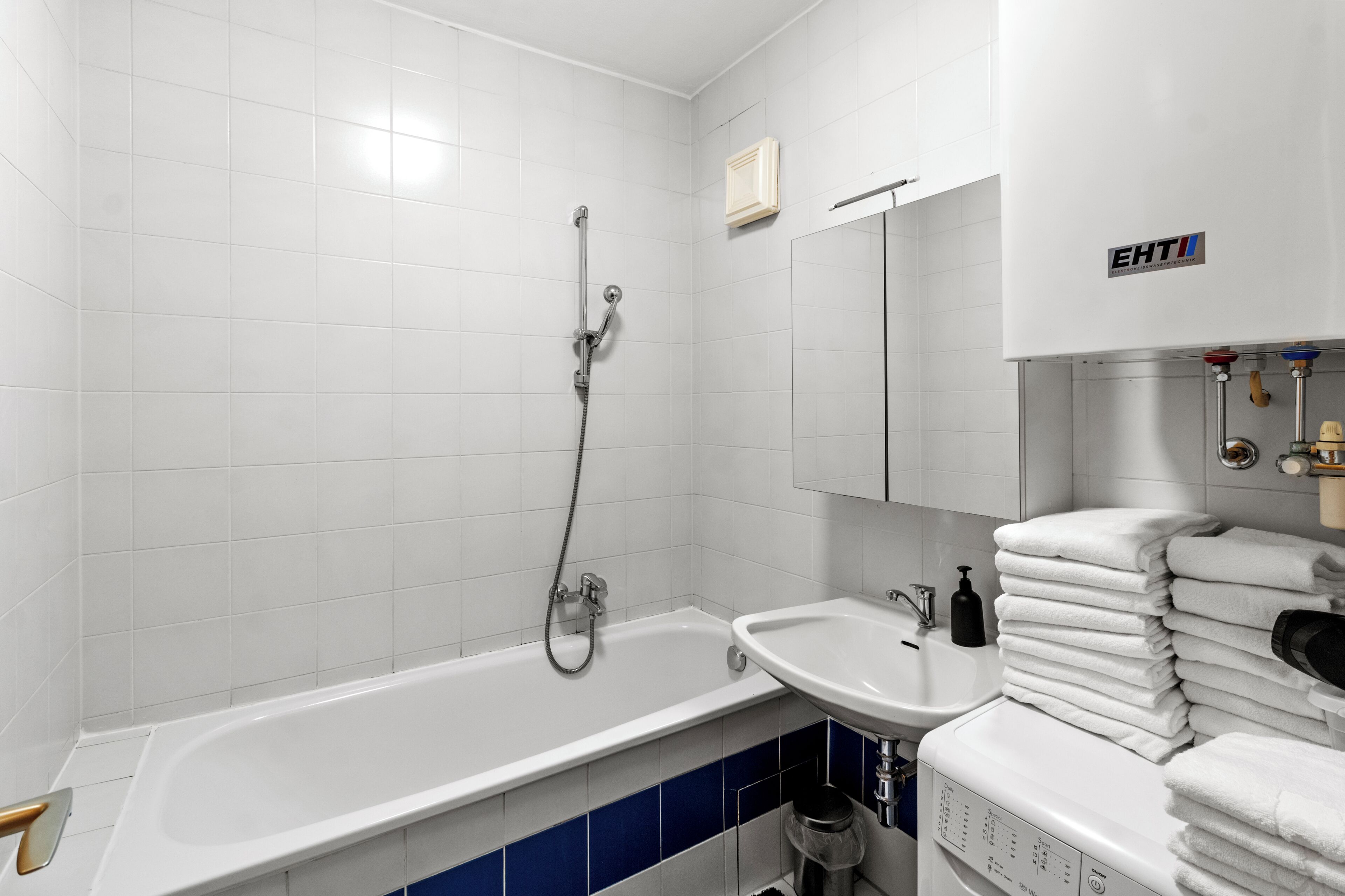 Une salle de bain moderne avec une baignoire, un lavabo et une pile de serviettes.