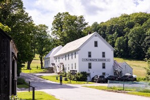 Un edificio bianco con un cartello che recita 'The Plymouth Cheese Corp.'