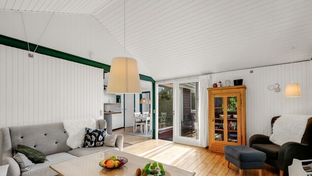 Ett modernt vardagsrum med en soffa, ett soffbord och en matplats.