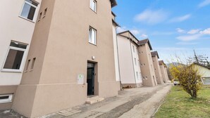A row of beige apartment buildings with a clear sky. - FarawayHomes Studios Leoben P74 (Donawitz)
