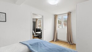 A room with a bed, a desk, and a window with curtains. - FarawayHomes Studios Leoben P74 (Donawitz)