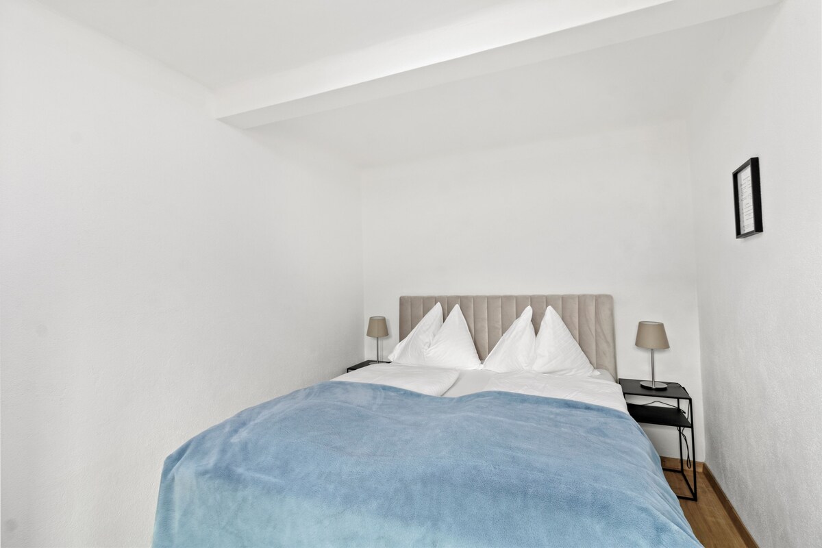 Une chambre à coucher avec un lit, deux tables de chevet et une commode.