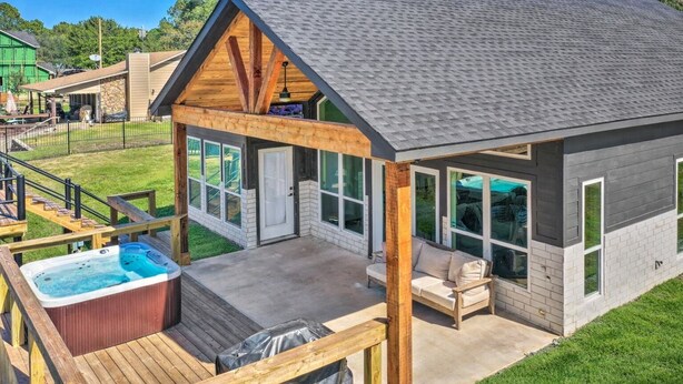 Une maison moderne dotée d’un porche couvert, d’un jacuzzi et d’une terrasse.