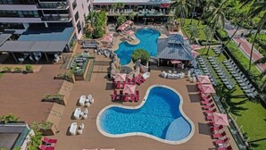 Ein Poolbereich auf dem Dach mit mehreren Pools, Liegestühlen und Sonnenschirmen.