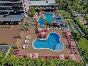 A rooftop pool area with multiple pools, lounge chairs, and umbrellas. - Spacious Ocean View Condo / Beach Service / 704 (Miami Beach)