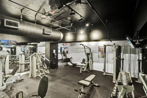 A gym with various exercise machines, a treadmill, and a bench. - Spacious Ocean View Condo / Beach Service / 704 (Miami Beach)