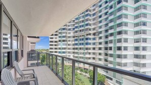 Ein Balkon mit Stühlen und Blick auf ein Hochhaus.