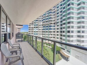 A balcony with chairs and a view of a high-rise building. - Spacious Ocean View Condo / Beach Service / 704 (Miami Beach)