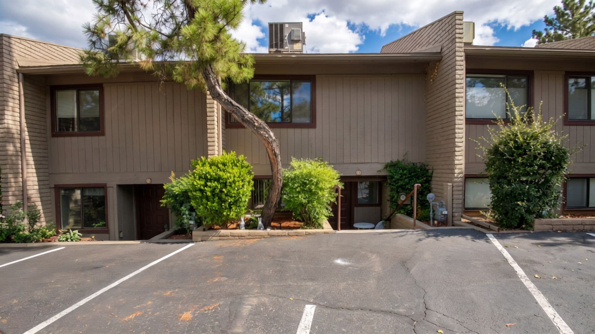 A multi-story building with a parking lot in front.