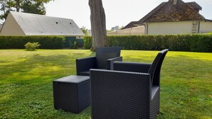 Ein Garten mit Gartenmöbeln und einer Hecke.