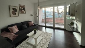 A modern living room with a sofa, coffee table, and artwork on the wall. - FarawayHomes Studio Bruck 17 (Bruck an der Mur)