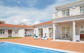 A poolside area with a swimming pool, lounge chairs, and a building with a balcony. - Luxurious home in Vabriga (Vabriga)