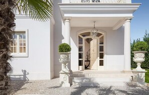 A white building with a grand entrance, a staircase, and two large urns on either side. - Luxurious home in Vabriga (Vabriga)