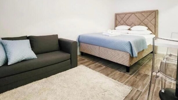 Una camera da letto moderna con un letto, una poltrona e una lampada da terra.
