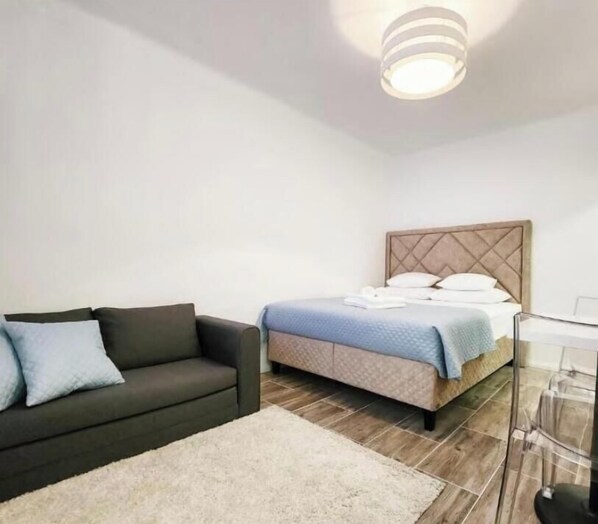 A modern bedroom with a bed, a sofa, and a floor lamp. - Cozy 1-bedroom studio in city center of Split, Croatia (Split)