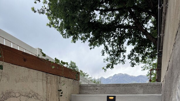 A set of concrete steps with embedded lighting fixtures, leading up to a white wall with a wooden ledge. - The Green Clover Hideaway-Cozy Studio Retreat with Fire Pit (Draper)