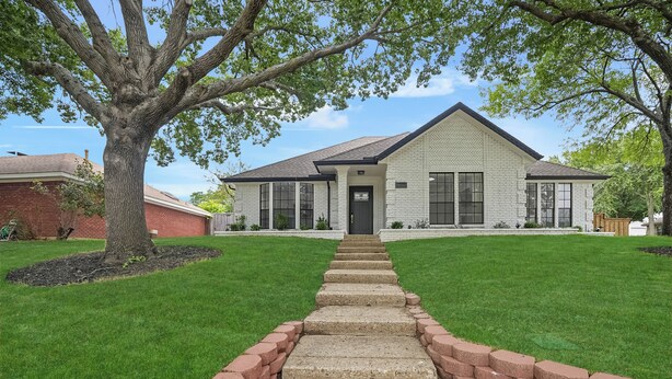 A two-story house with a front lawn, a pathway leading to the front door, and a large tree on the left. - Paradiso in Frisco, A perfect home away from home in North, Dallas! (Frisco)