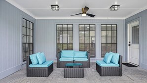 A covered patio area with wicker furniture, ceiling fans, and large windows. - Paradiso in Frisco, A perfect home away from home in North, Dallas! (Frisco)