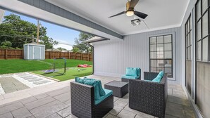 A covered patio with wicker furniture, a ceiling fan, and a view of a backyard. - Paradiso in Frisco, A perfect home away from home in North, Dallas! (Frisco)