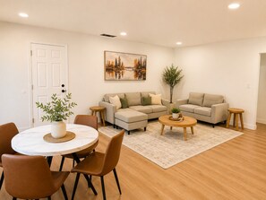 A living room with a round dining table, two sofas, a coffee table, and a potted plant. - Kid/Pet-Friendly Entire 3BR Home w/ AC Good for Extended Stays (San Jose)