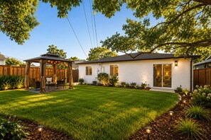 A residential backyard with a covered patio, a lawn, and a house with a sliding glass door. - Kid/Pet-Friendly Entire 3BR Home w/ AC Good for Extended Stays (San Jose)