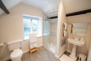 A modern bathroom with a toilet, shower, and sink. - Grimsbury Castle - Luxury Cottages (Hermitage)