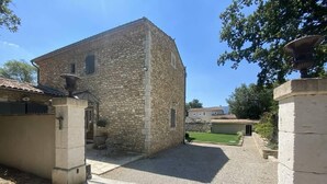 A stone building with a gravel courtyard, a small garden, and a paved path. - Stone farmhouse in the heart of the Luberon (Ménerbes)
