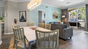 Un espace repas comprenant une table et des chaises, un canapé et un lustre.