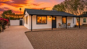 A single-story house with a patio area, a small outdoor seating space, and a gravel driveway. - Modern Lux Stay: Near Downtown, Sky Harbor and ASU (Phoenix)