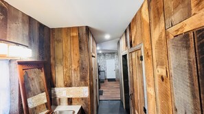 Ein Korridor mit Holzwänden und einem Waschbecken.