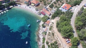 Vista aérea de un pueblo costero con casas, una playa y barcos.