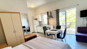 Un dormitorio con cama, escritorio y kitchenette.
