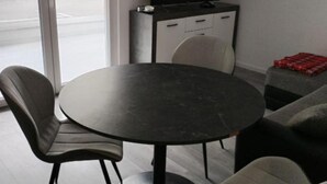 A modern room with a round table, two chairs, a sofa, a cabinet, and a TV. - Comfort Apartments Orma (Povljana)
