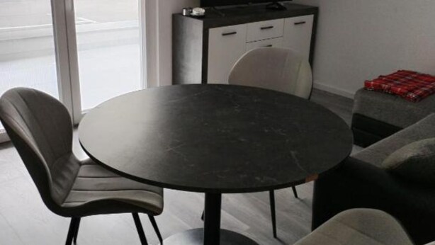A modern room with a round table, two chairs, a sofa, a cabinet, and a TV. - Comfort Apartments Orma (Povljana)