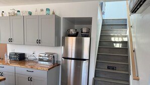 A kitchen with a stainless steel refrigerator, a toaster, and a water dispenser. - Spacious 2-bedroom house in Stone Ridge with outdoor patio with beautiful view. (Stone Ridge)