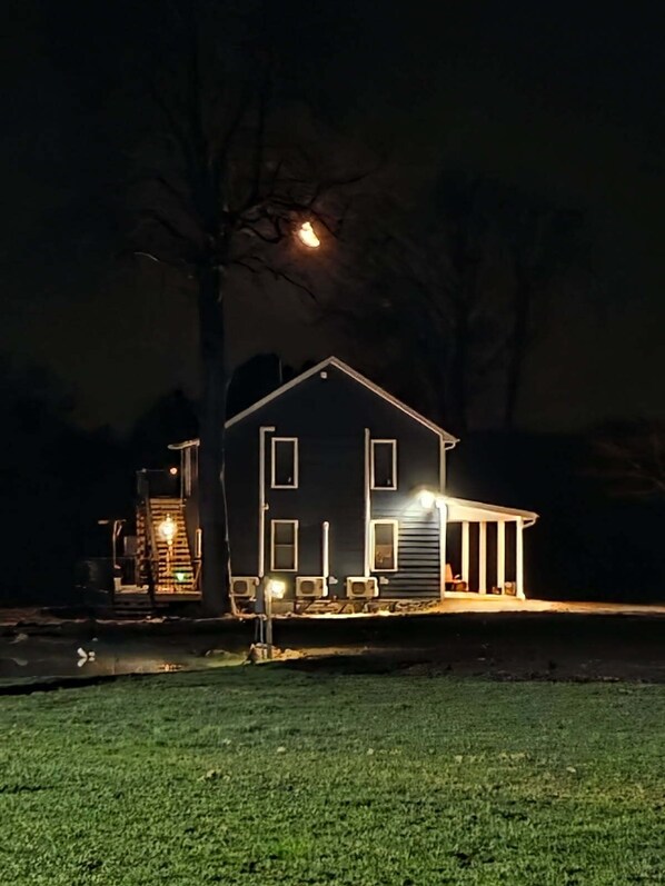 Ein Haus mit Veranda, Garage und einem Baum im Hintergrund.