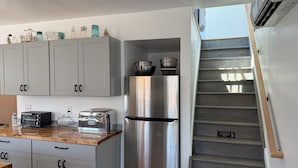 A kitchen with white cabinets, a stainless steel refrigerator, a toaster, and a wooden countertop. - Spacious 2-bedroom house in Stone Ridge with outdoor patio with beautiful view. (Stone Ridge)