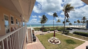A hotel balcony with a view of the beach, palm trees, and a parking area. - Oceanfront Escape on Hollywood Beach (Hollywood)