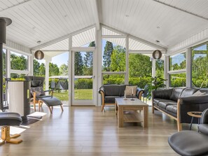 A spacious room with a high ceiling, large windows, a fireplace, and a variety of seating options. - "Saja" - 30km from the sea by Interhome (Toftlund)