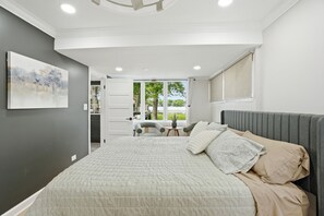 Un dormitorio con cama, un cuadro, una ventana y vistas al exterior.