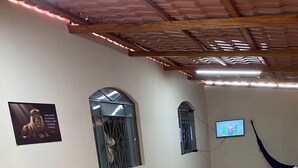 A room with a tiled floor, a hammock, a television, and decorative windows. - Your perfect family retreat (Divinópolis)