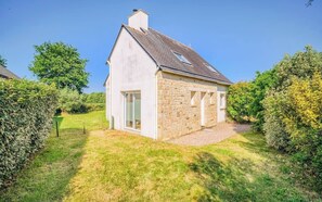 Ein kleines Steinhaus mit geneigtem Dach, einer Tür und einem Fenster.