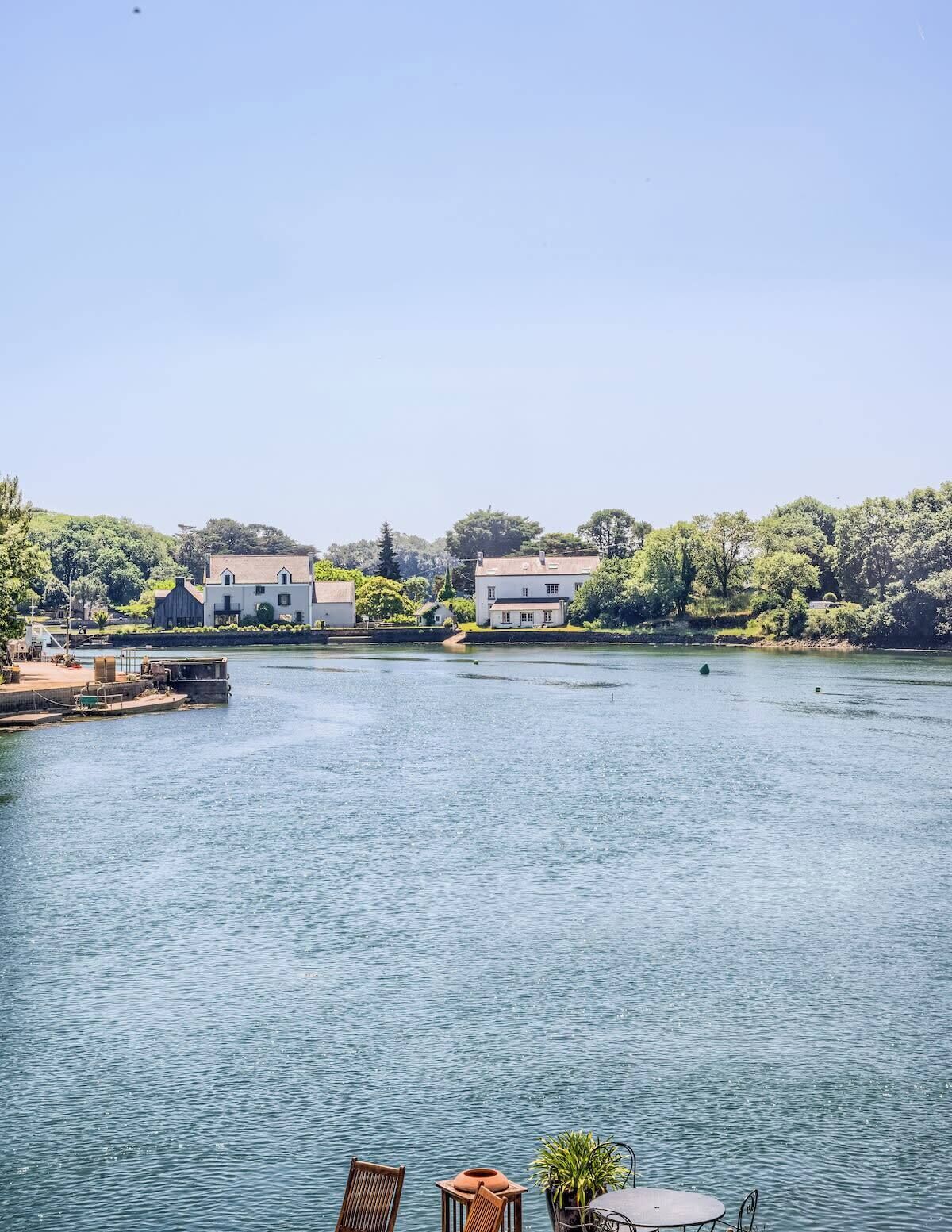 Une propriété située au bord de l’eau, dotée d’un quai, d’un petit bateau et d’une rangée de maisons.