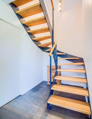 Eine moderne Wendeltreppe mit Holzbodenstufen und Metallgeländern.