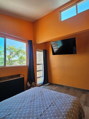 A bedroom with a bed, a TV mounted on the wall, a window with curtains, and a fan. - Family Weekend: Private Pool, Barbeque, Sun and Relaxation (Xochitepec)