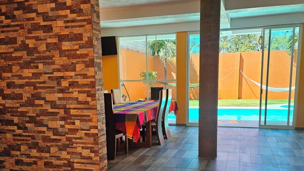 A spacious room with a tiled floor, a dining area with a table and chairs, and a view of a swimming pool. - Family Weekend: Private Pool, Barbeque, Sun and Relaxation (Xochitepec)
