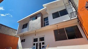 A multi-story building with a balcony, large windows, and a visible door. - Family Weekend: Private Pool, Barbeque, Sun and Relaxation (Xochitepec)