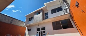 A multi-story building with a balcony, large windows, and a visible door. - Family Weekend: Private Pool, Barbeque, Sun and Relaxation (Xochitepec)