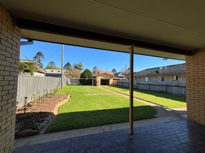 A covered patio area with a view of a backyard.